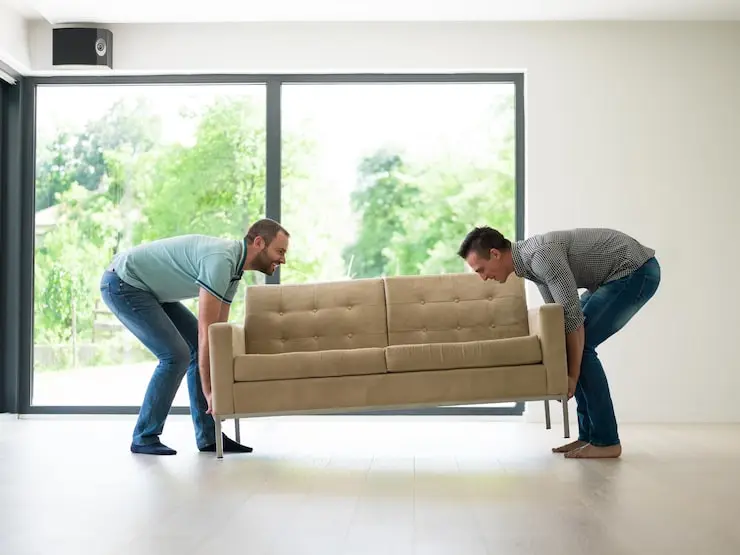 Professional Junk Masterz team performing a furniture removal service to demonstrate how to get rid of a couch from a residential home.