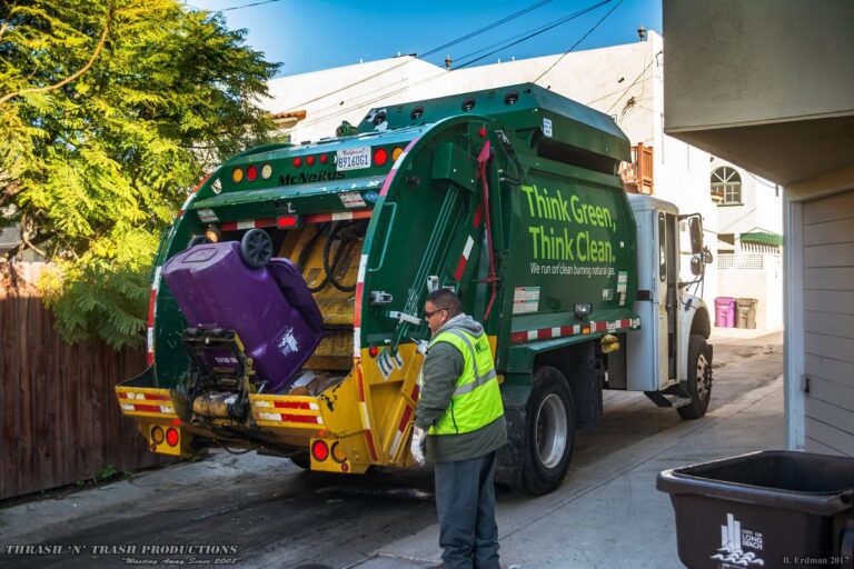 “Yard waste dumpster rental filled with branches, leaves, and landscaping debris in a residential driveway”