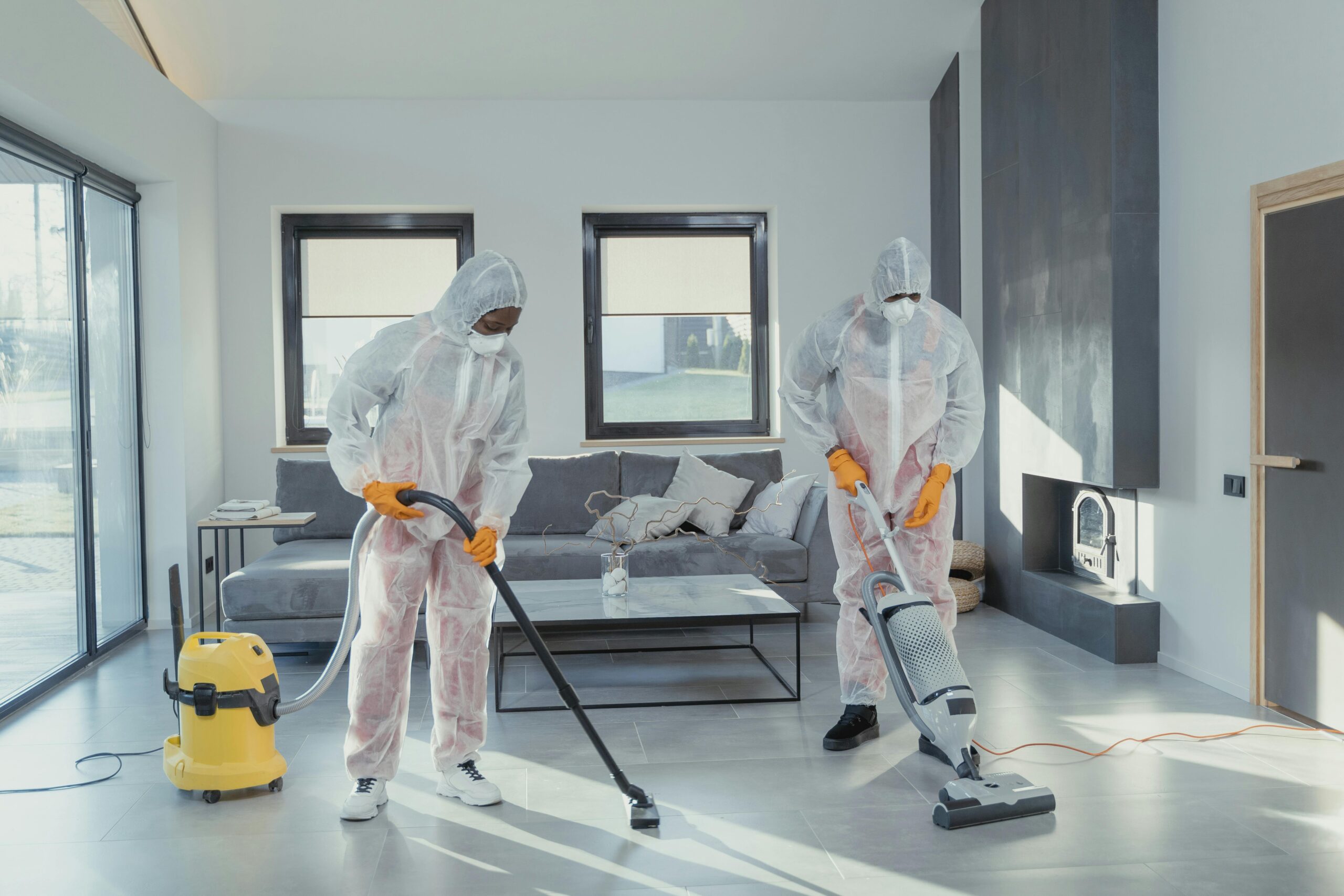 Professional cleaner vacuuming a living room floor illustrating how much house cleaning cost for a typical professional house cleaning service.